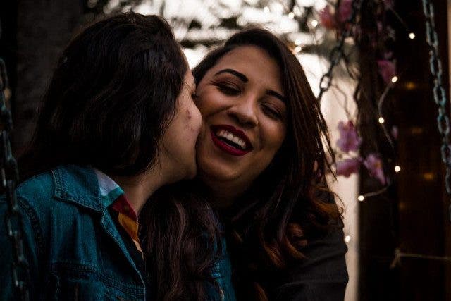 l smiling women kissing anotherwoman 2546890