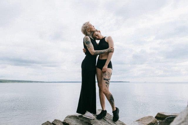woman in black tank dress standing on rock near body of 3727663 1