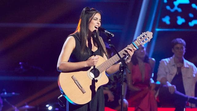 Chiara Oliver cantando con su guitarra